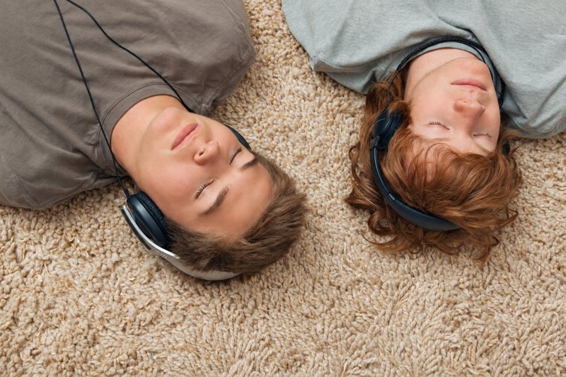 Deux adolescents allongés, casques sur les oreilles
